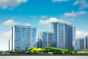 Vue extérieure d’un immeuble neuf au design moderne, bordé par un parc verdoyant.
